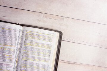 Used and Highlighted Bible Open on a White Wood Table