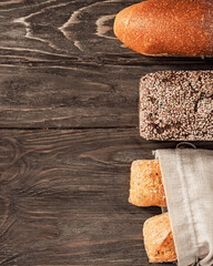 Fresh loaves of assorted bread on an old wooden background with copy space. Food background