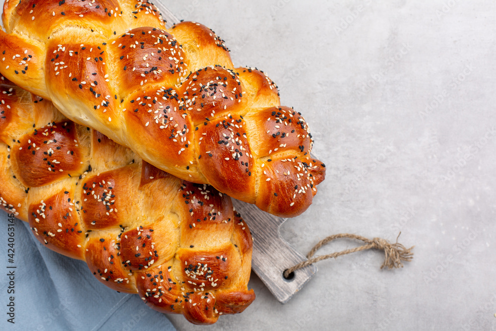 Canvas Prints Homemade braided bread decorated with sesame seeds. Top view. Light grey background.