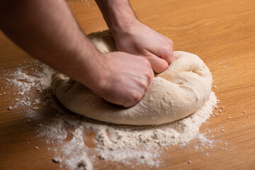 Kneading dough on a wooden table.