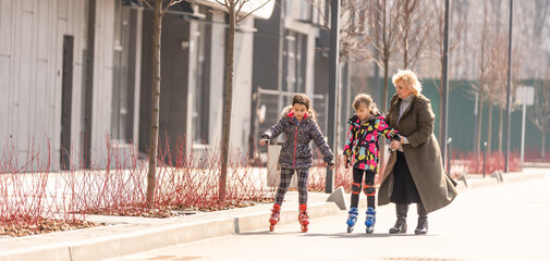 grandmother teaches granddaughter to roller skate