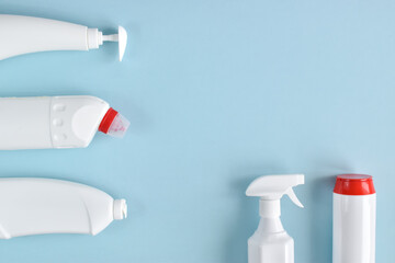 White detergent bottles on a blue background. Flat lay