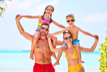 Happy family in colorful swimsuits on beach