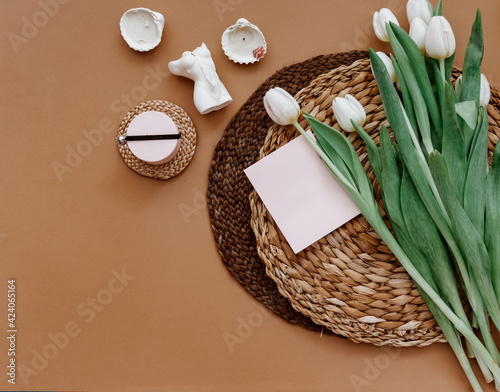Spring composition. White tulips, coffee cup, candle on brown background. Mother day, 8 march. Blank greeting card. Flat Lay