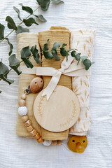 Fototapeta na wymiar Newborn Background. baby muslin with a bow and bib. Empty wooden card. Gift for a newborn baby
