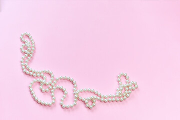 Feminine desktop mockup with pearls on pink background with copy space.