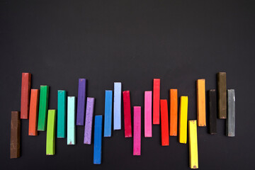 Colorful chalks on blackboard. Space above for text. Concept of drawing and LGBTI.