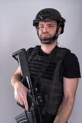 Airsoft equipped male making funny faces to the left of the camera