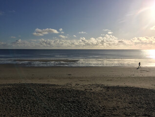 A man walking alone on Douglas beach  on a winter day at low tide, Isle of Man