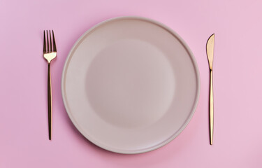 Pink plate and cutlery on the pink background. Perfect for romantic dinner