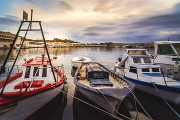 Fototapeta premium fishing boats in the fishing port of Almeria with the Alcazaba in the background overlooking the city at sunrise
