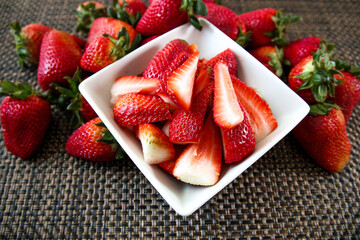 Strawberries whole and cut in white bowl