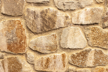 Stone fence or wall, close-up, side view. Concept details of the exterior of the house, decor options, protection, safety. Background, texture with place for text, copy space. Horizontal