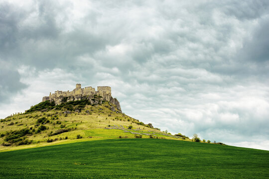 spis, slovakia - 29 APR 2019: castle ruins on the hill. grassy meadow in the foreground. popular travel destination on a cloudy day