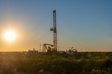 pulling equipment in oil field at sunset