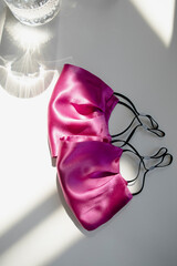 silk quarantine masks. fashion masks against the virus and dust. lilac protective masks on a white background top view.
