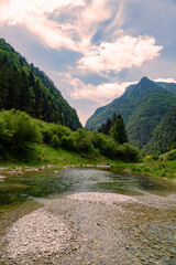 Fototapeta na wymiar Stream with its refreshing water between the mountain peaks