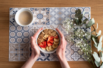 Bol de fresas plátano y cereales con café y paniculata.