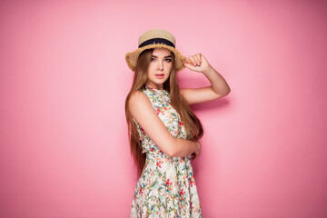 Winsome girl in romantic dress with flower print and straw hat p