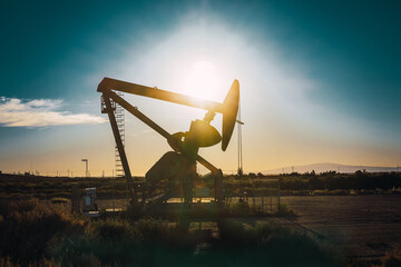 Oil pump and oil refining factory at sunset. Energy industrial concept