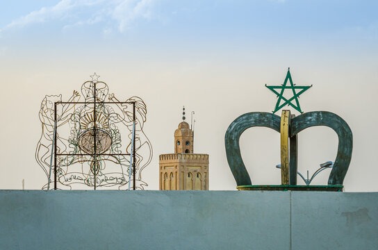 Midelt, Morocco - April 10, 2014.  Moroccan symbols on the roof with minaret tower