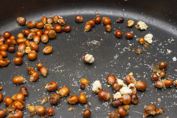 Popcorn kernels almost popped in bottom of pan with salt
