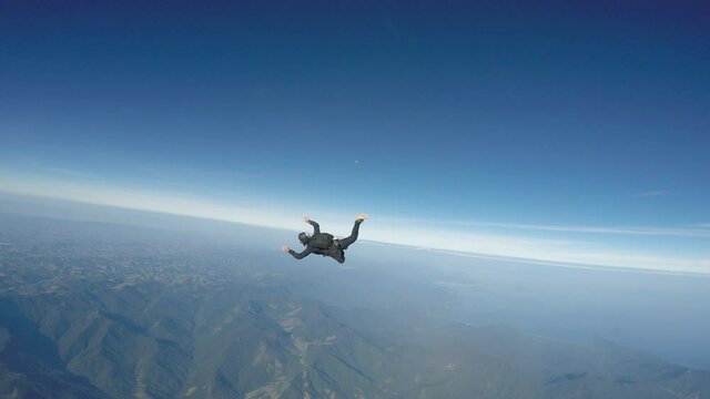 Skydiver jump over the Paraty beach. Fish eye lens. (Distorted image)