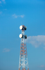 Telecommunication tower with antennas on a background of blue sky and clouds. Smart antennas transmit 4G and 5G cellular signals to consumers.