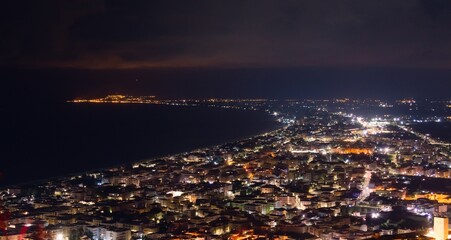 Fototapeta na wymiar Aerial night view of the city of Terracina, Italy, by the Mediterranean sea.