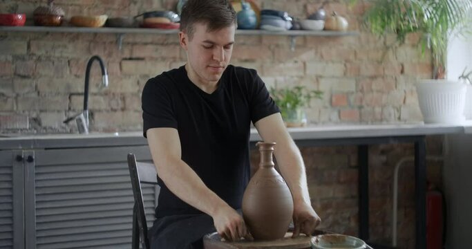 Close up view: potter separates the molded nerikomi pot from the potter's wheel, pottery workshop, ceramics craftsmanship, 4k 60p Prores HQ 10 bit
