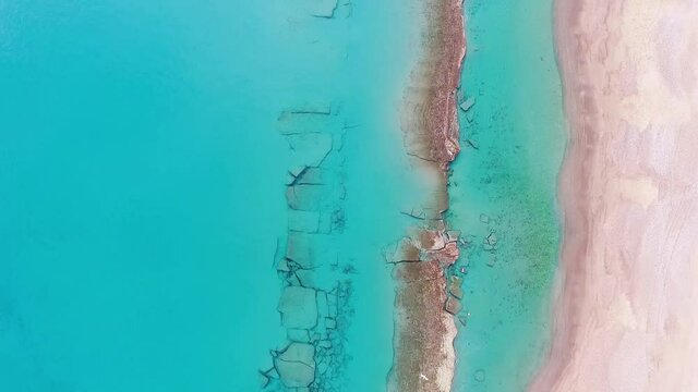 Flight over the beach and beach-rock near Ancient Asine, Greece, and the beautiful turquoise sea on a calm day