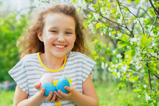 Easter egg hunt concept. Little girl keeps colorful painted eggs on Easter Day. child hunting eggs in grass.