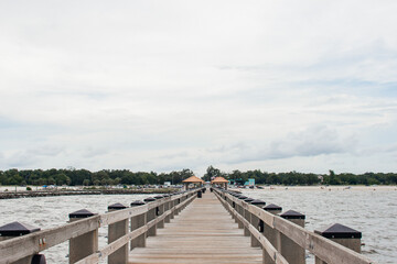 Obraz premium Seascape. Wooden pier with gazebos with orange roofs. Summer background. Ken Combs Pier, Gulfport, MS, USA