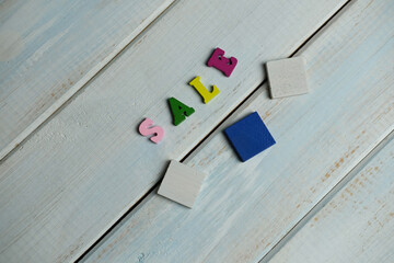 bright word sale on light blue wooden background, shopping concept for vacation, travel, bargain...