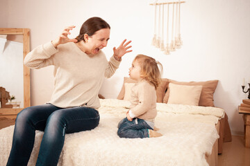 Mom yells Screams angry at baby. A two-year-old girl is afraid of her mother. The woman is nervous...