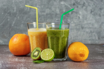 Two tall glasses of orange juice and a banana-orange kiwi and spinach smoothie