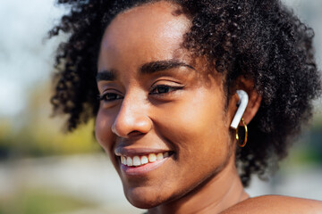 Afro athletic woman standing outdoors.