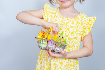 Cropped photo of girl with a shopping basket filled with Easter decorations.
