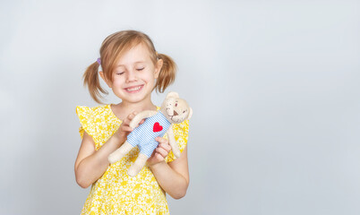 Little Caucasian girl with teddy bear with closed eyes