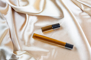 A container for storing cosmetics made of dark glass lie on the folds of a silk