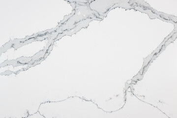 Close up of a quartz slab that contains both bold grey veins and subtle thin veins