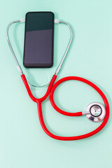 Fototapeta na wymiar Top view of a stethoscope in a smartphone headset. Medical, communications and technology concept