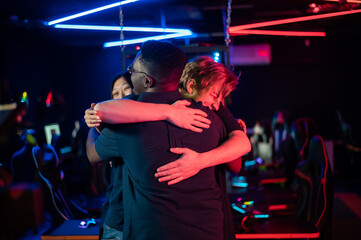 After winning the cyber tournament, the guys and the girl hug each other for joy