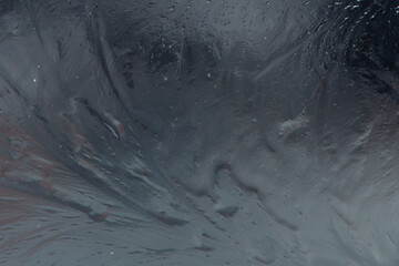 Frozen crystallized water and ice, on the surface of the blue ocean with a slight skim of frozen water. The frosty ice has been broken with cool cracks of transparent frost along with the ice shifts. 