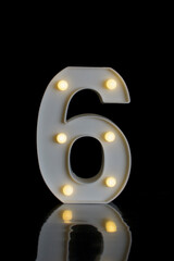 Number 5 (five), in a plastic part, with round flashing lights, with black background on a reflective surface