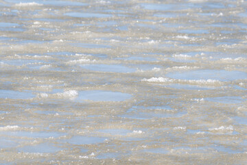 Frozen crystallized water and ice, on the surface of the blue ocean with a slight skim of frozen...