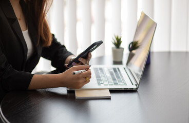 Fototapeta premium Portrait of Asian young female working on tablet at office