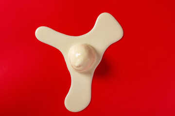 Fototapeta premium top view half melted vanilla flavor ice cream ball on red background