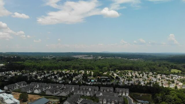 Aerial view of a sprawling suburb with a busy highway and cluster of houses in an upscale subdivision