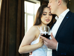 Young newlywed couple drinking wine and smiling at their happiness, romance and tenderness